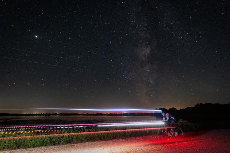 A cyclist racing their bike in the Day Across Minnesota at night